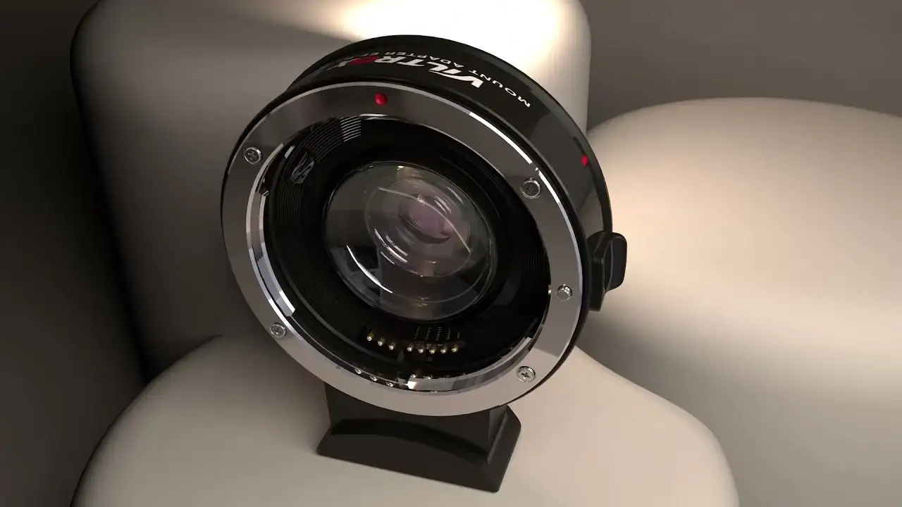 Тривимірний рендер фокального редуктора Viltrox EF-FX2, встановленого вертикально на вбудовану ніжку з різьбою для штатива, видно блиск металевого кільця кріплення